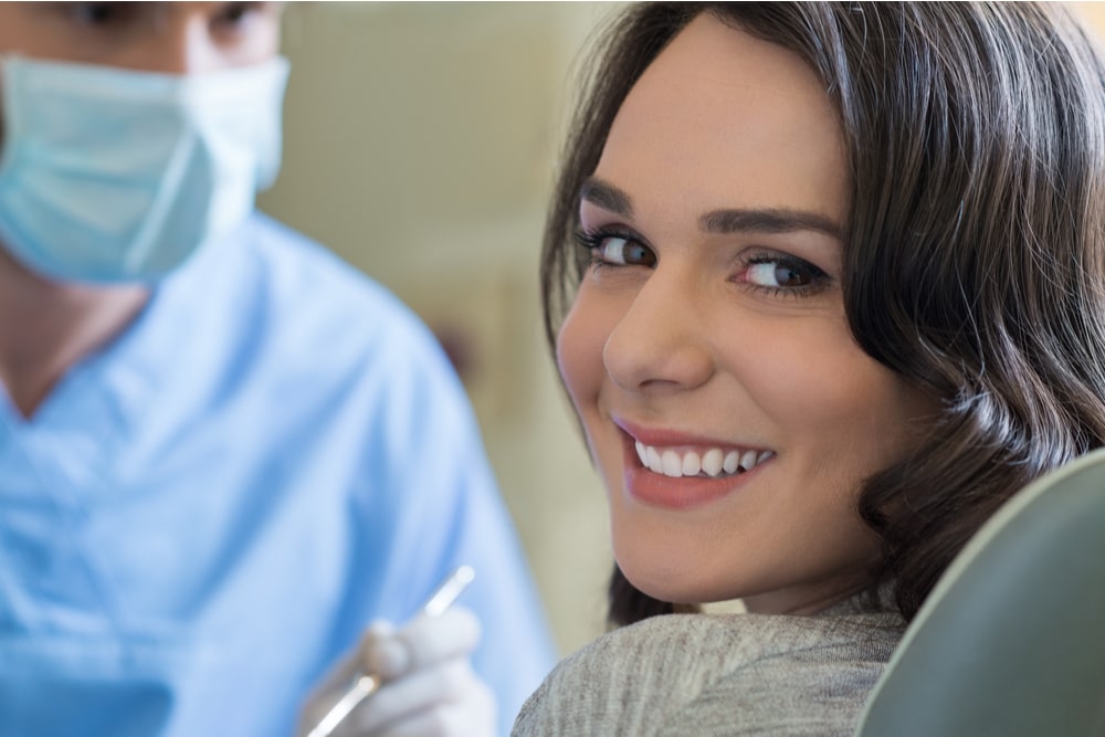 Smiling young woman receiving dental checkup