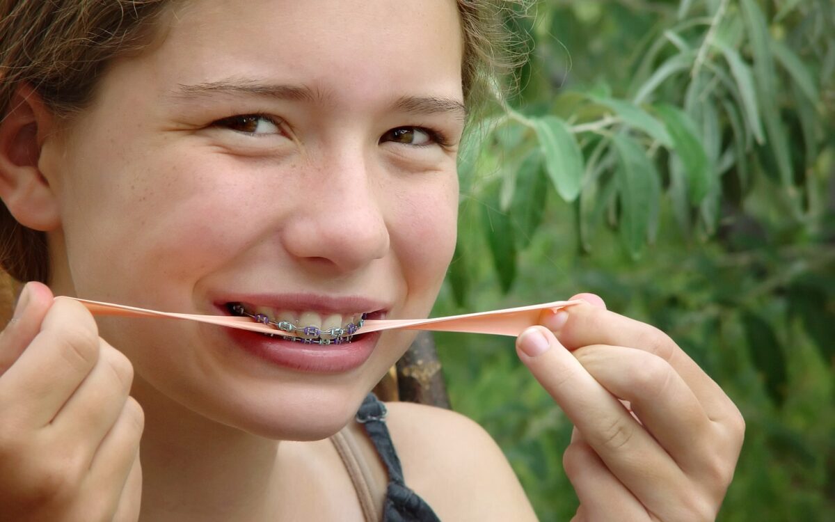 Young Woman Chewing Gum with Braces